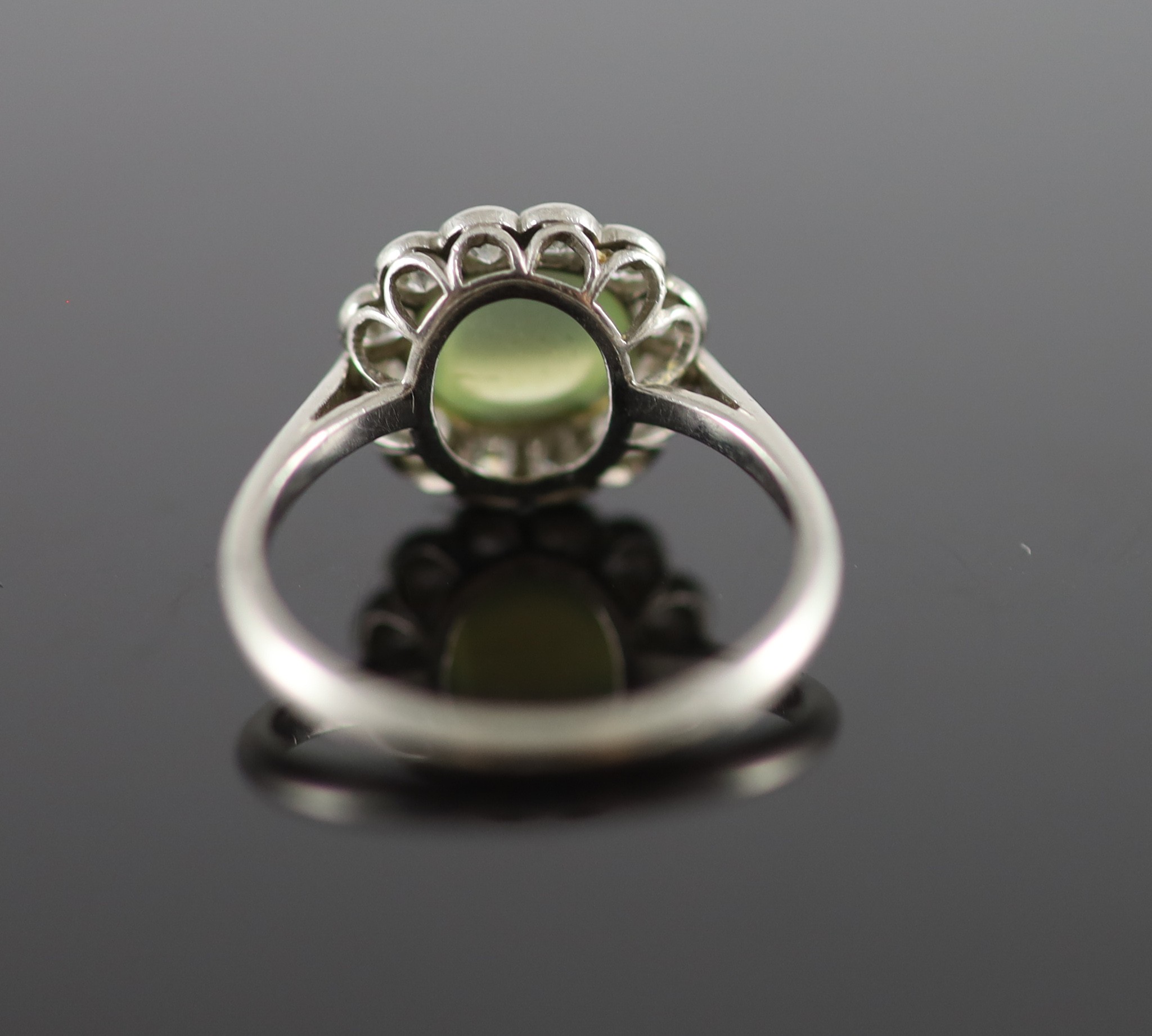 A 1920's/1930's platinum, cats eye chrysoberyl and diamond set oval cluster ring